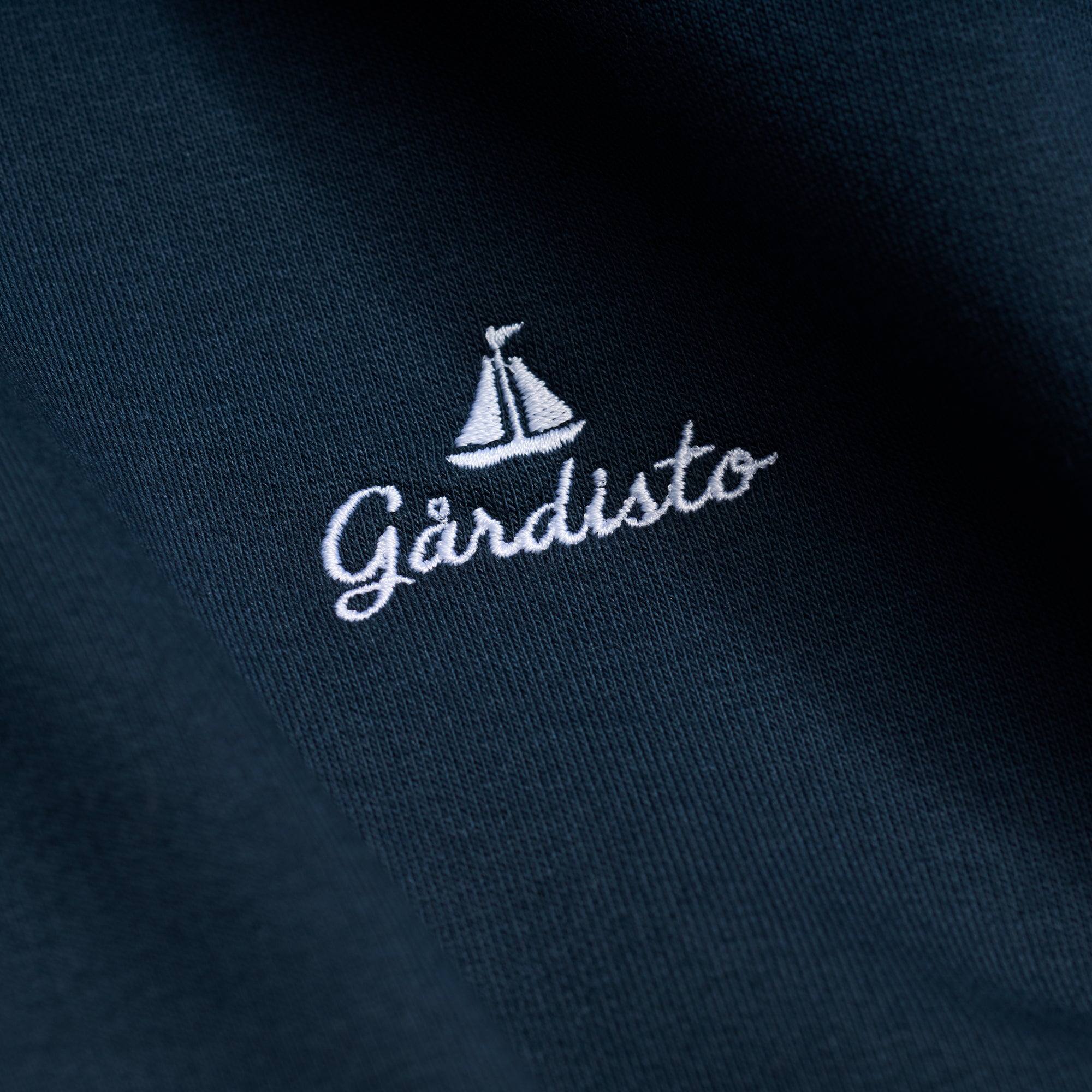 Embroidered Gårdisto sailboat logo on navy hoodie