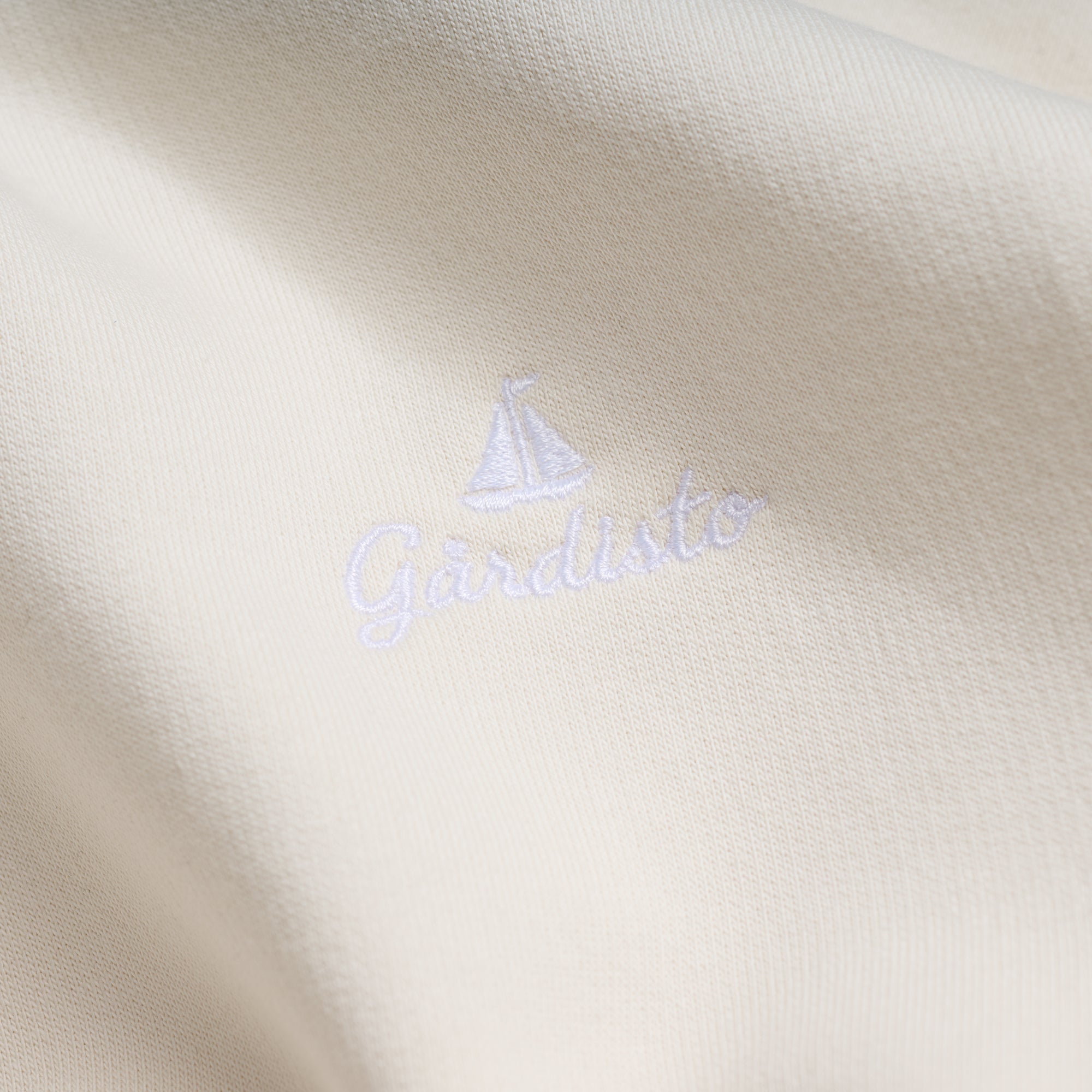 Embroidered Gårdisto sailboat logo on sand hoodie