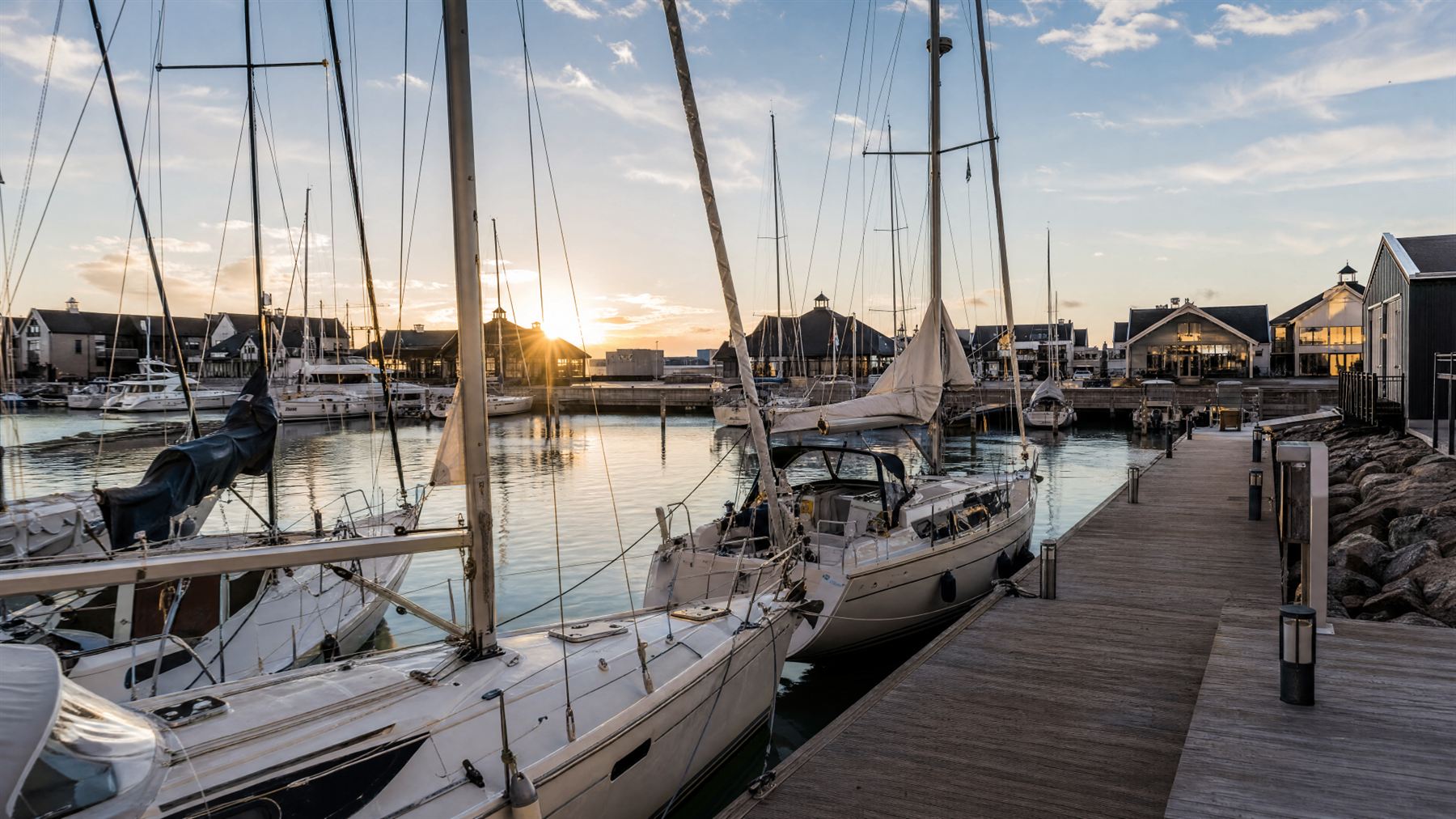 Sejlbåde i en stille nordisk marina ved solnedgang